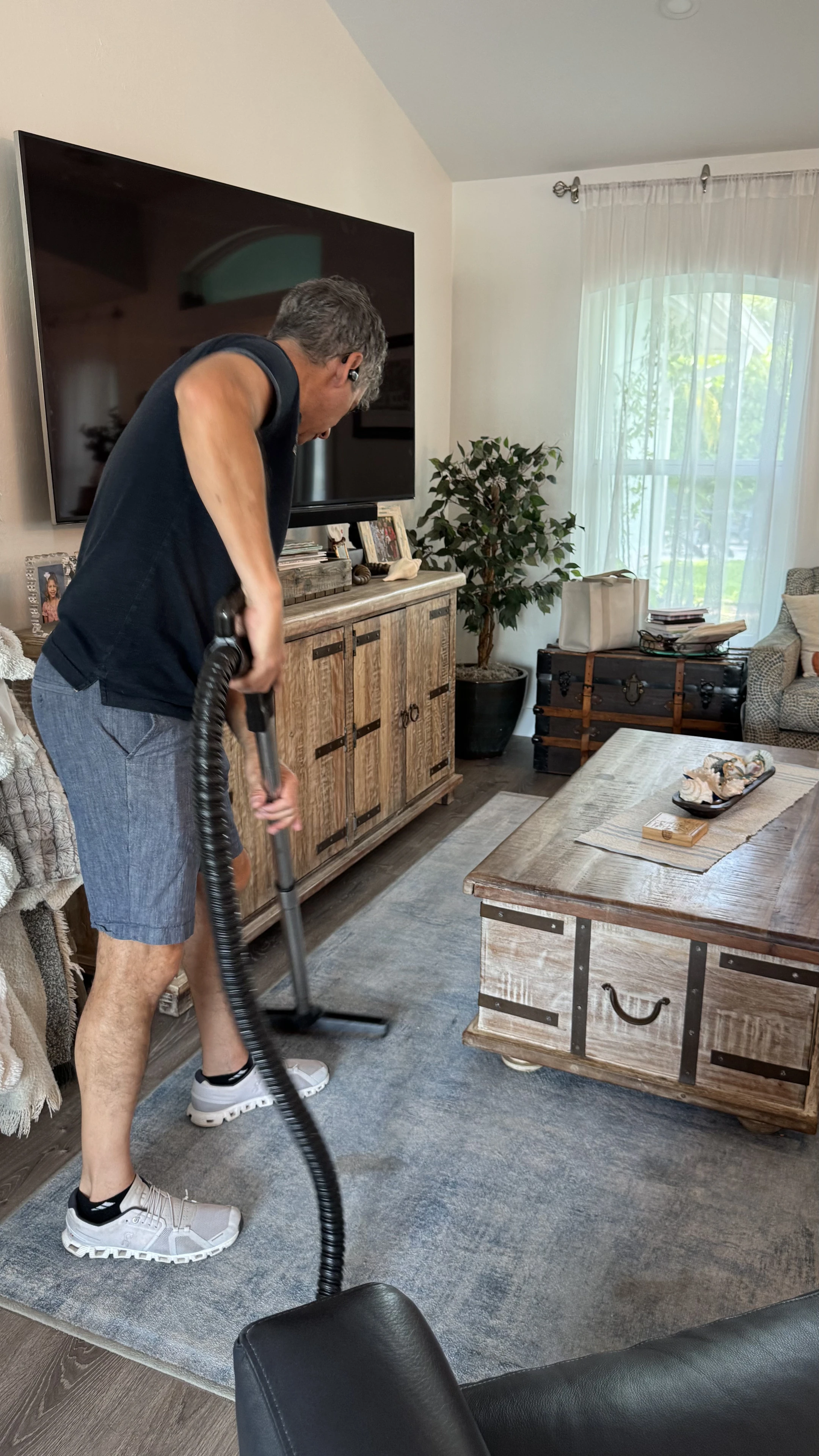 Smart Green team member vacuuming a living-room rug