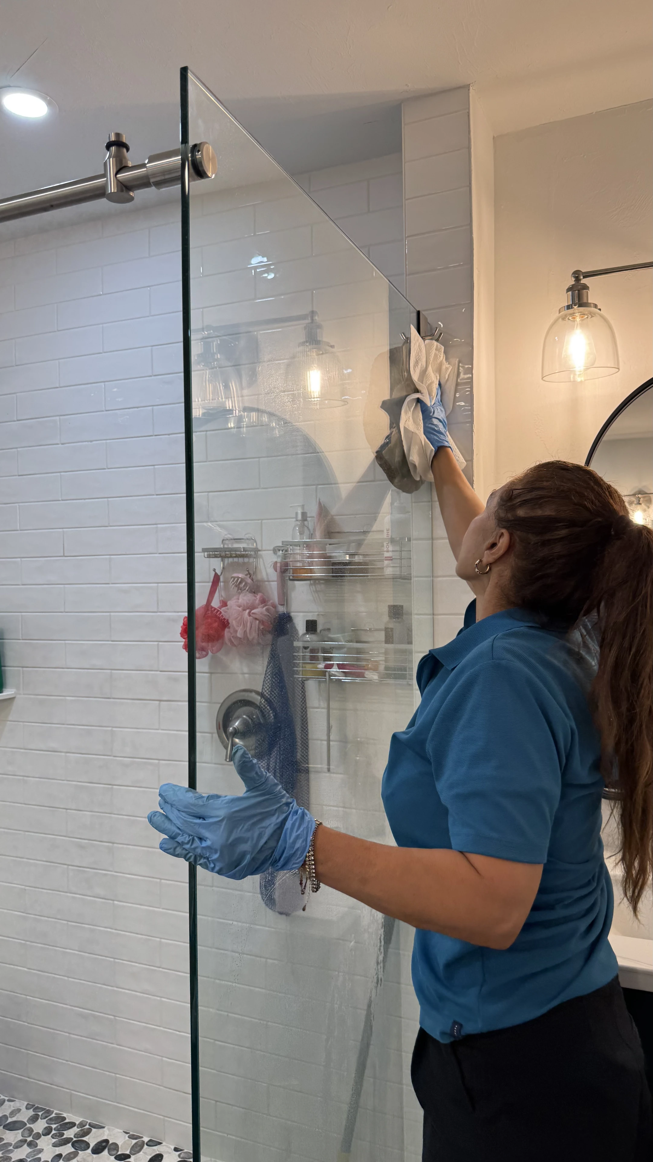 Smart Green team member wiping a glass shower enclosure